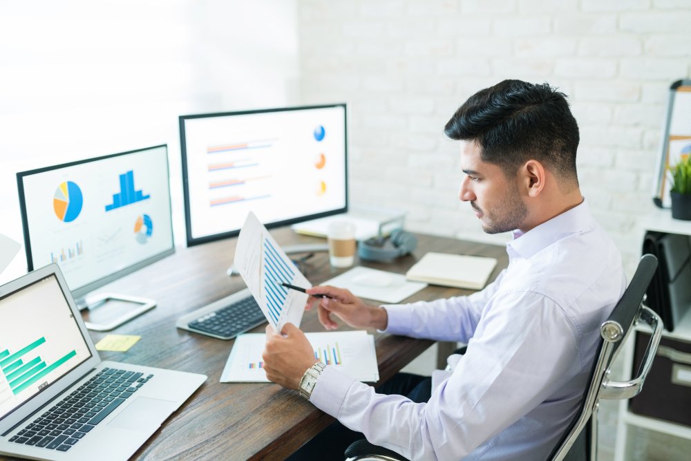 handsome latin businessman examining sales data while working home (1)